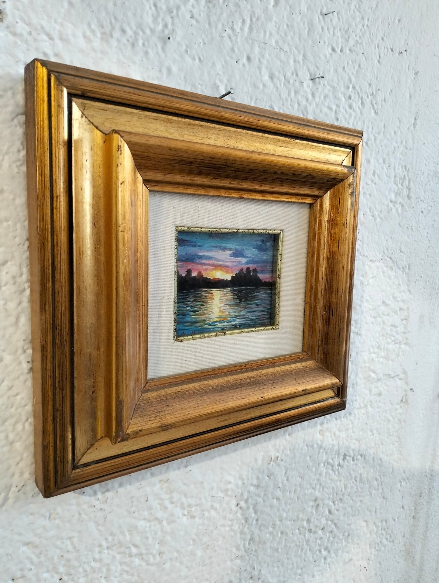 Hand painted picture of a sunset with a golden frame
