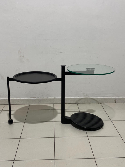Tavolino vintage design industriale con piano in vetro girevole Ø45cm h60cm, struttura in metallo nero con ruota - anni ‘80 Modern