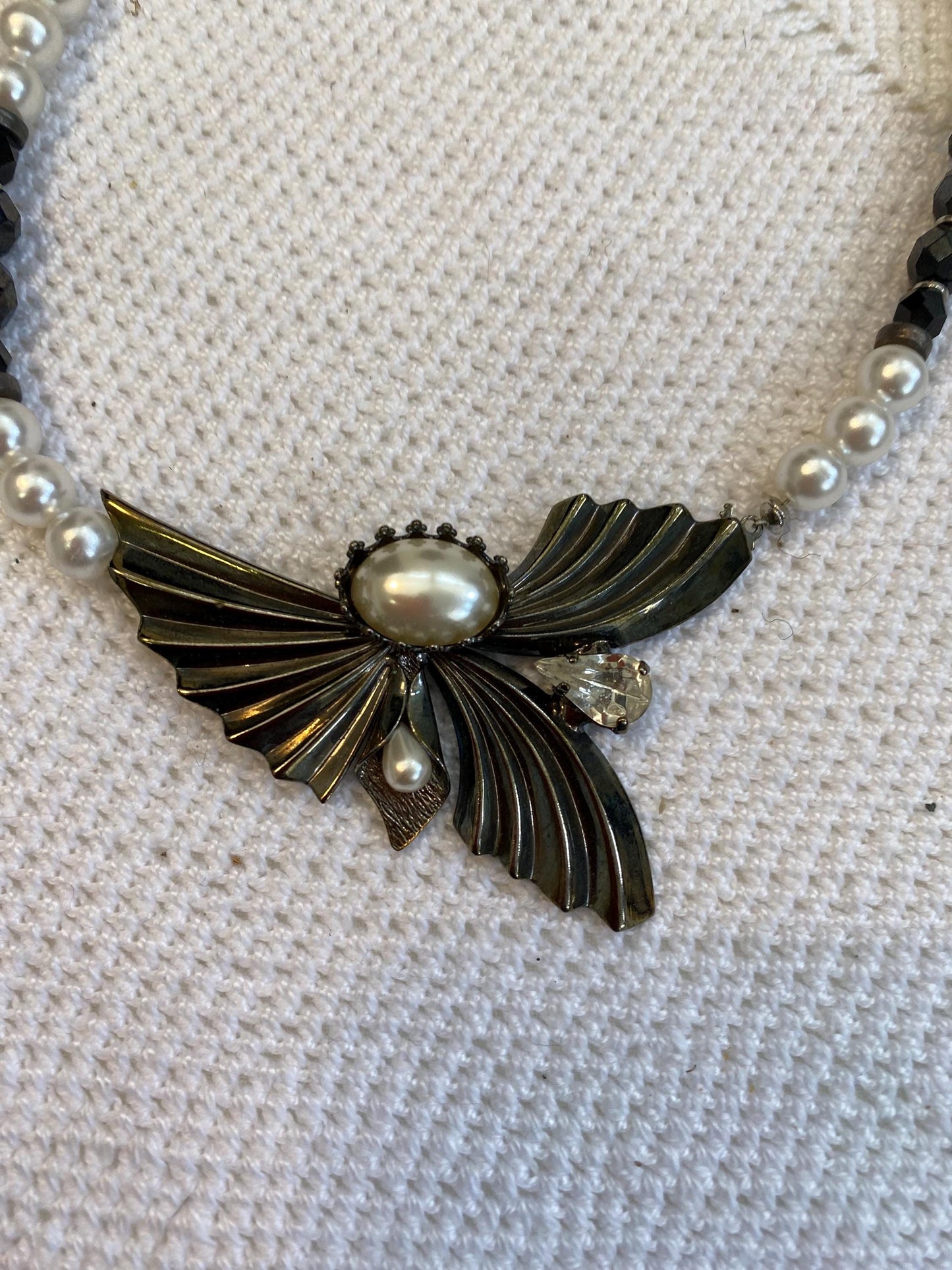 Collana sintetica perline bianche nere con ciondolo ali dorate e perla centrale, diametro 13 cm, gioiello fatto a mano elegante