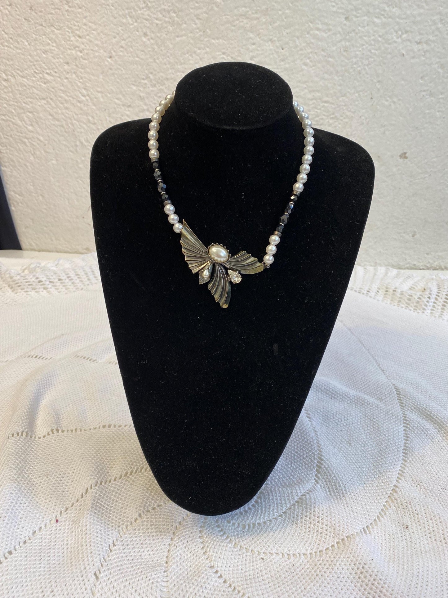 Collana sintetica perline bianche nere con ciondolo ali dorate e perla centrale, diametro 13 cm, gioiello fatto a mano elegante