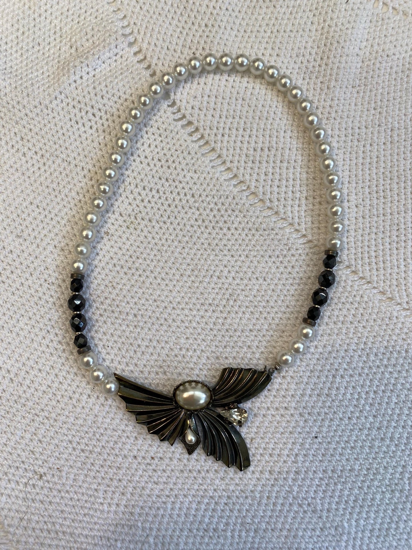 Collana sintetica perline bianche nere con ciondolo ali dorate e perla centrale, diametro 13 cm, gioiello fatto a mano elegante